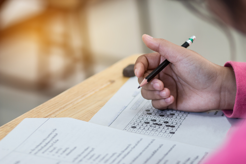 Student's hand holding pencil while taking an exam